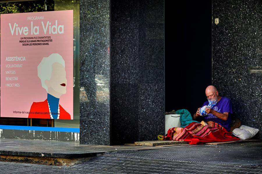 Un hombre sin hogar cena en Barcelona. (EFE)